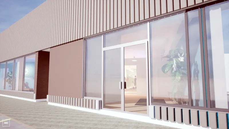 Midtown studio — glazed entrance and metal-clad frontage beside the paved approach.
