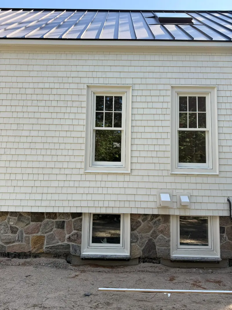 Shingle cladding and stone base with new windows.