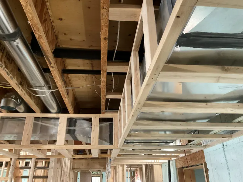 Exposed timber framing with new ductwork and wiring.