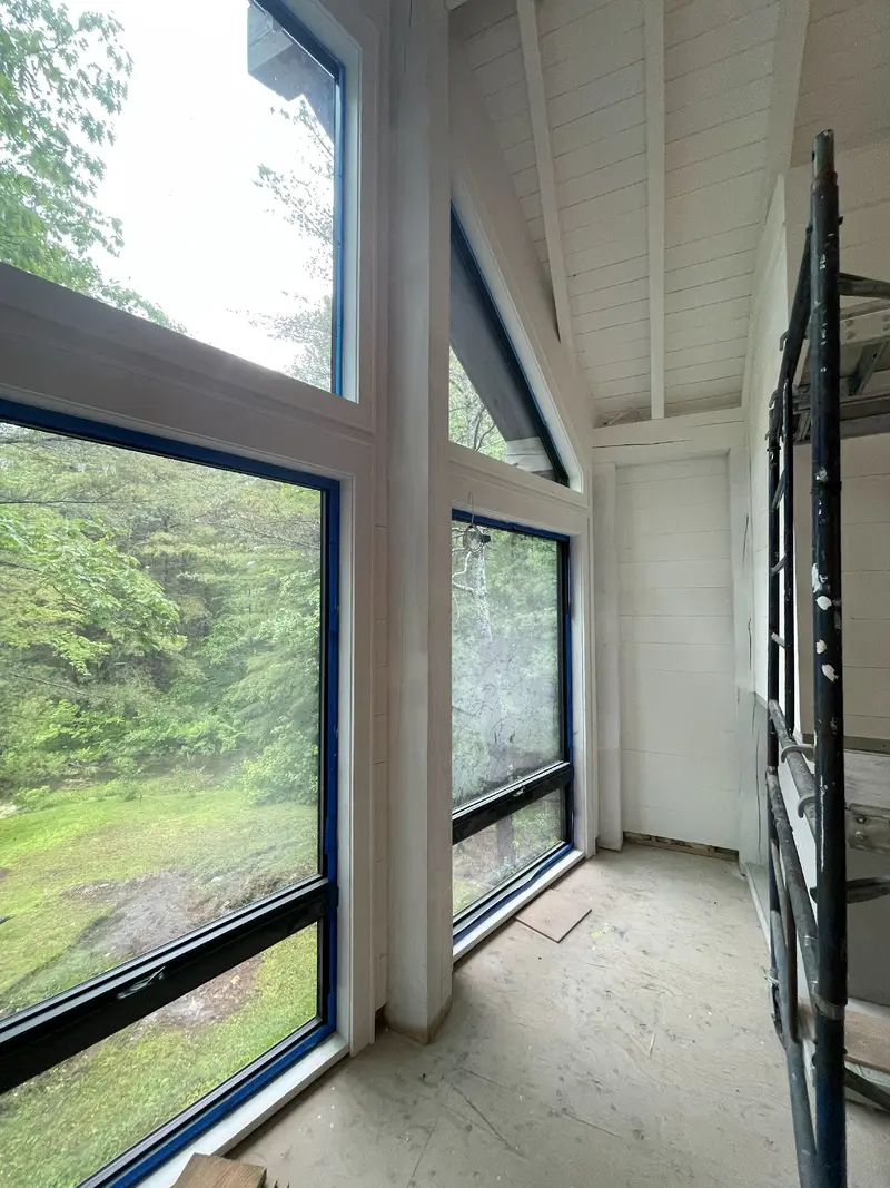 Tall glazing and painted timber ceiling during interior work.