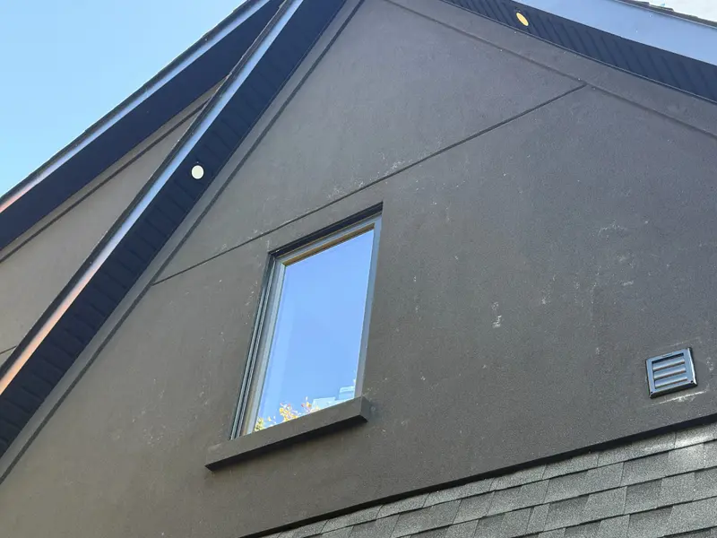 New stucco gable and dark soffit at the side elevation.