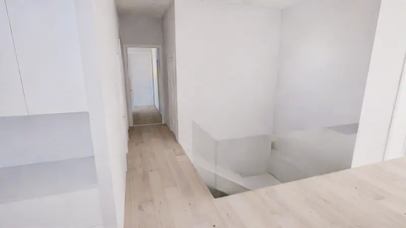 Pale timber floor and white stair opening beside a narrow hallway.