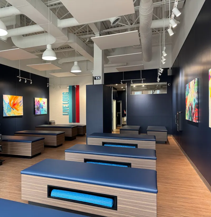 Completed Aurora studio — timber treatment benches beneath pendant lights and white ceiling baffles.