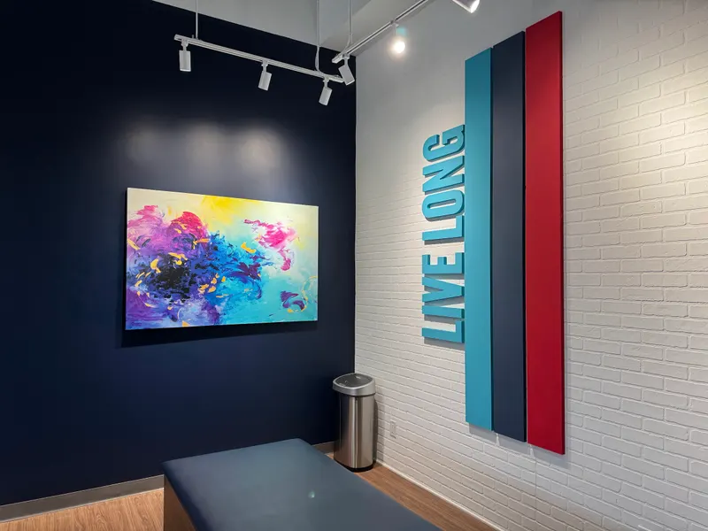 Completed Aurora studio — blue wall and striped brand panel beside a treatment bench.
