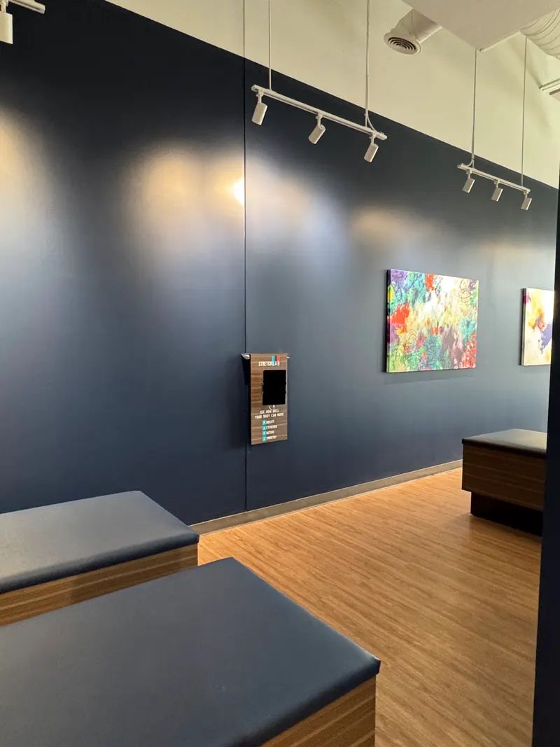 Completed Aurora studio — blue walls, colourful artwork and timber flooring.