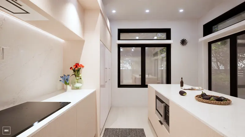 Long white kitchen island beside garden windows and pale full-height cabinetry.