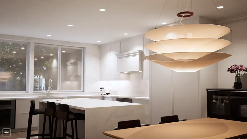 White kitchen island beside a timber dining table beneath a layered pendant.